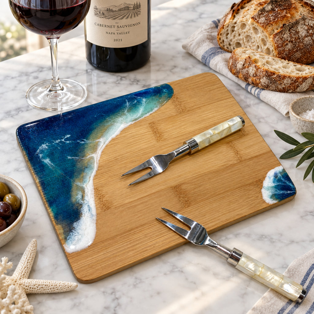 bamboo board with ocean theme resin art and two forks displayed on marble counter