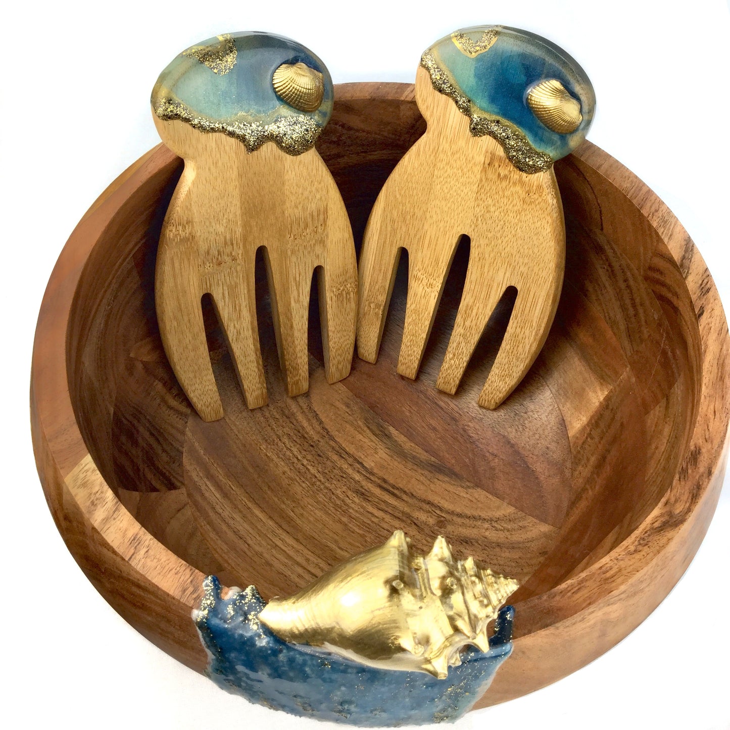 A close up of Wooden salad bowl set with resin art, shells and sand