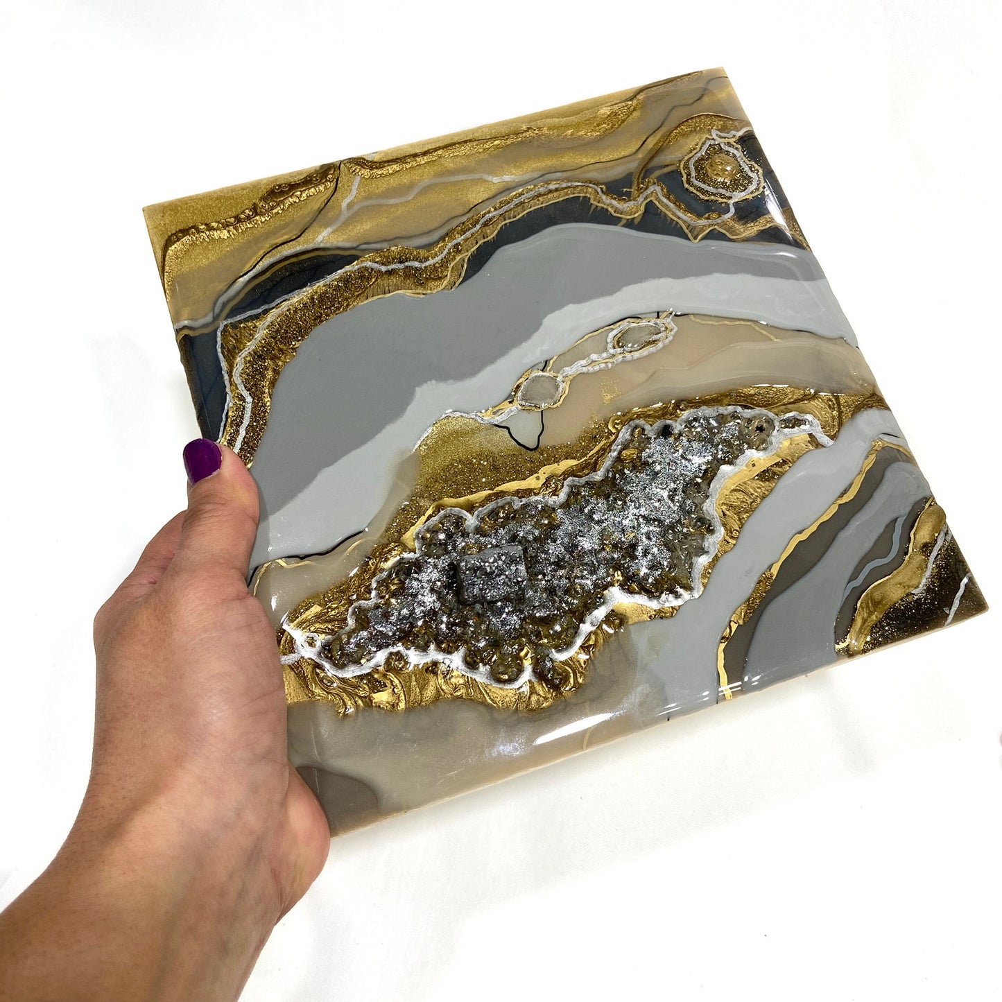 close up of the silver and gray geode held by someone's hand