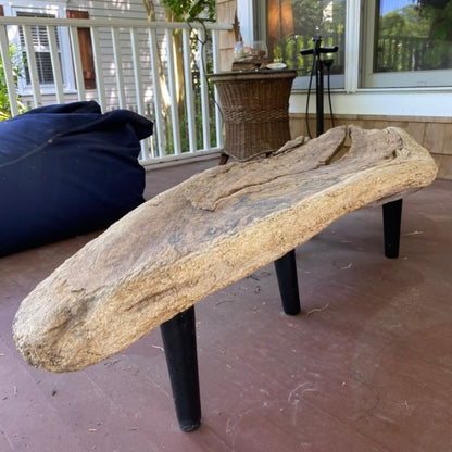 Organic driftwood table with black legs in a porch setting