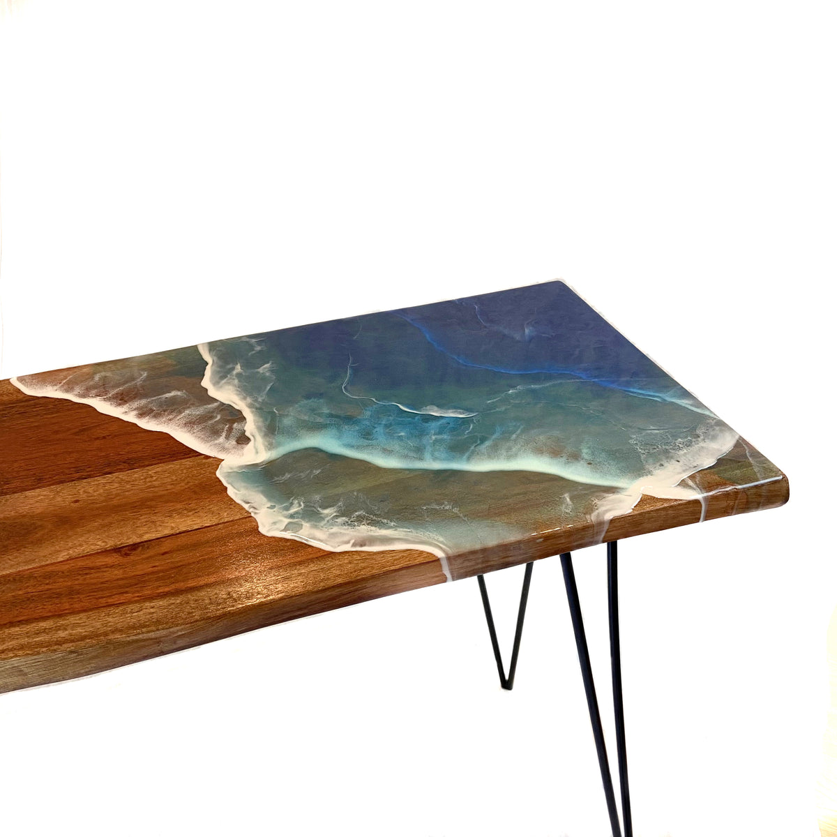 a close up of a resin ocean wave on a wood slab table on white background