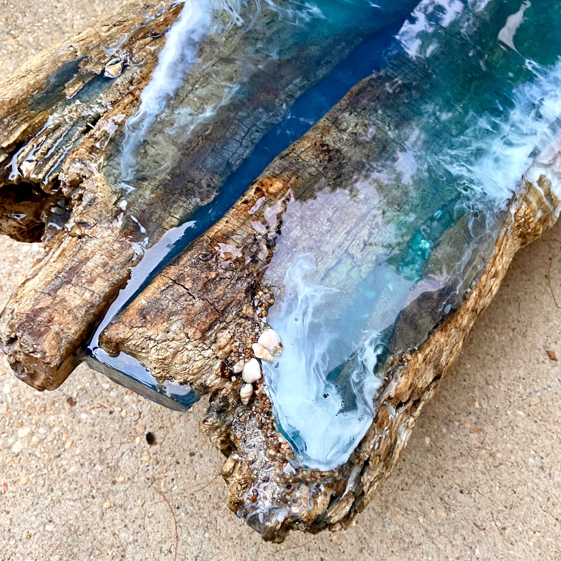 Partial image of a a blue resin wave on organic natural wood