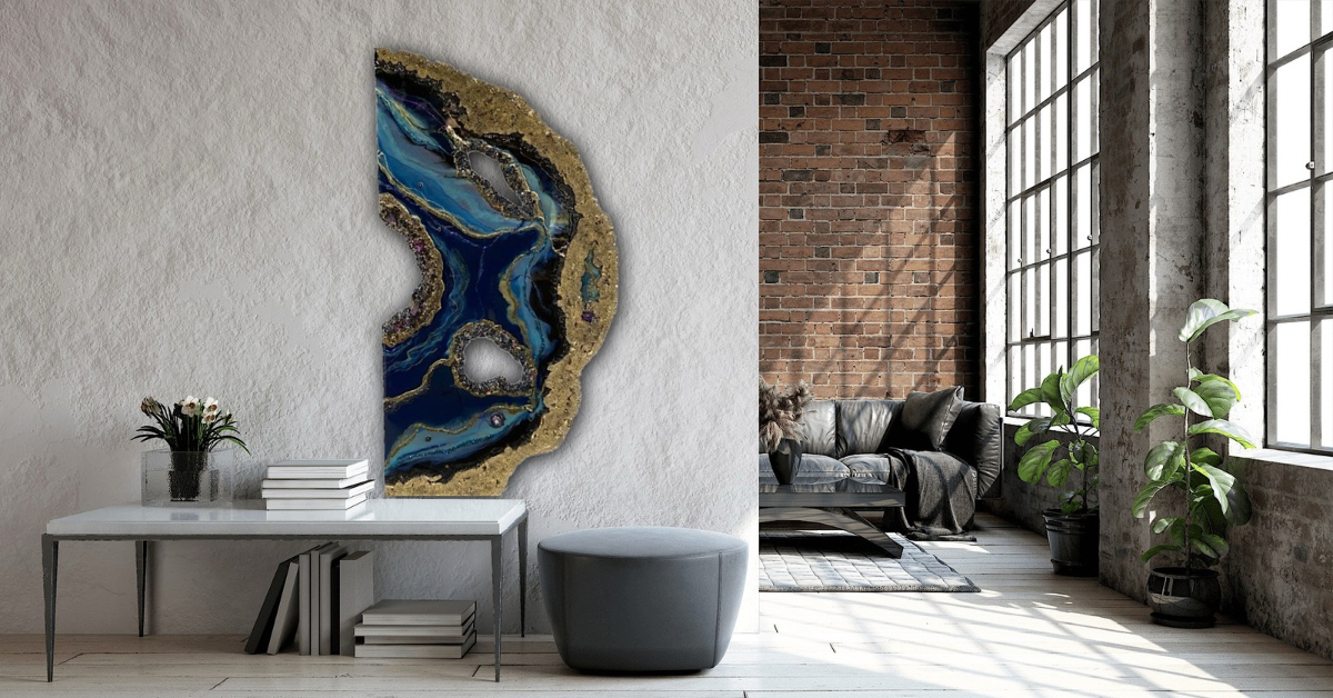 Midnight Geode wall art in deep blue and gold leaning on a modern console table in a gray-toned living space