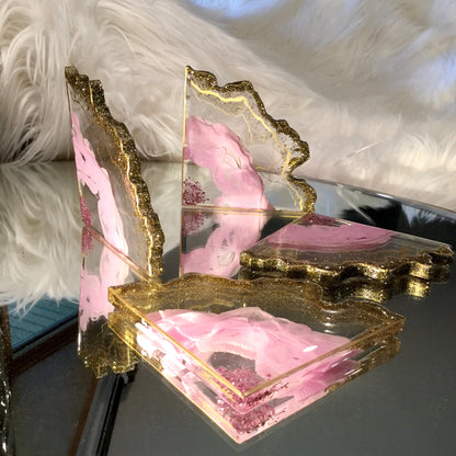 Pink coasters with clear background and gold accents displayed on a mirror table  - mamota creative
