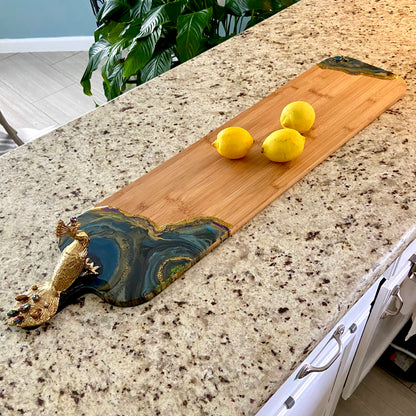 Peacock Royale serving board measuring 36 inches long with resin art embellishment