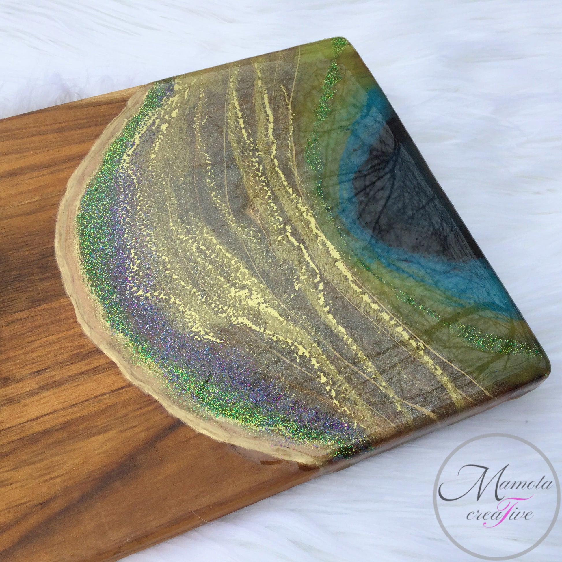 A close up of one end of The peacock resin serving board - extra large with gold peacock statue - Mamota Creative